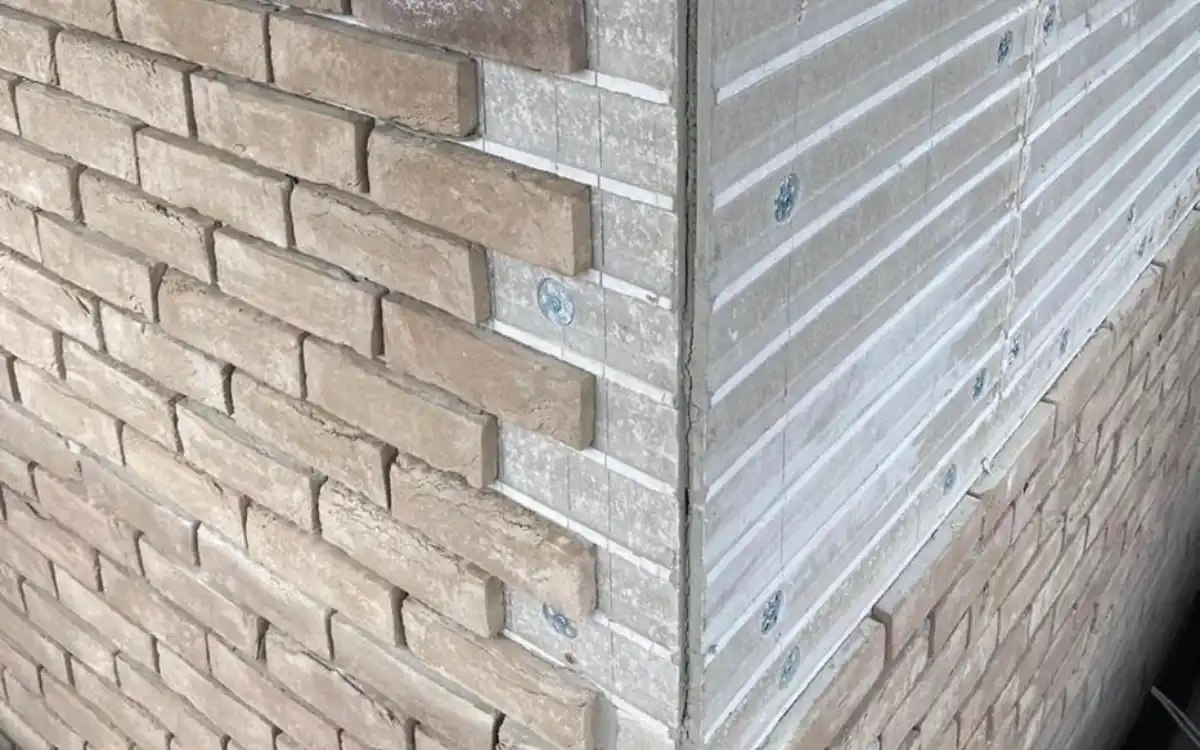 Real clay brick slips being bonded to the backing board with flexible adhesive on a home extension