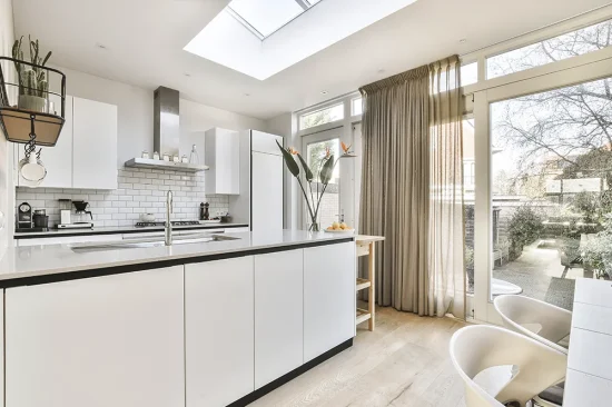 Kitchen diner extension featuring full-width glass doors and oak flooring
